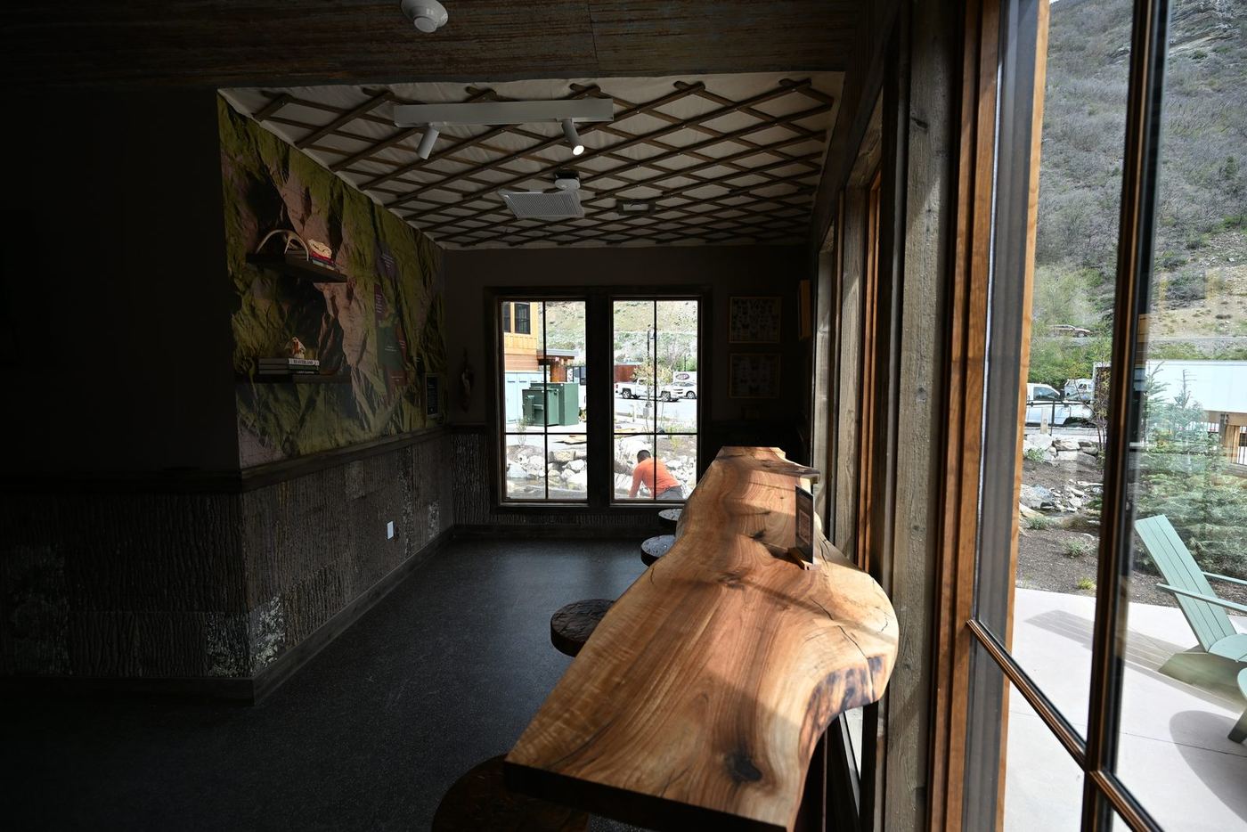 Live-edge wood counter beside floor-to-ceiling windows