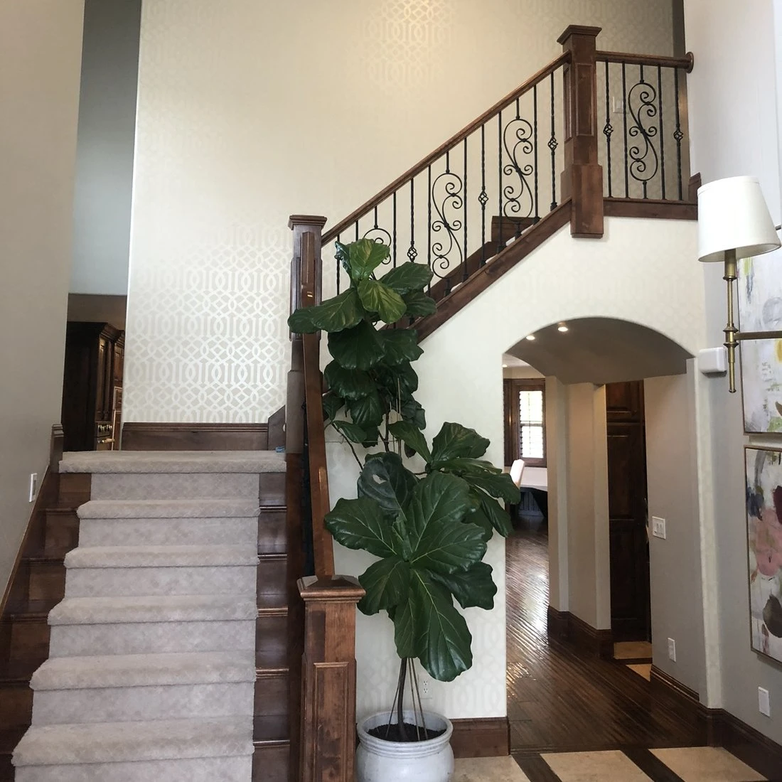Entryway before: dark wood staircase and beige walls