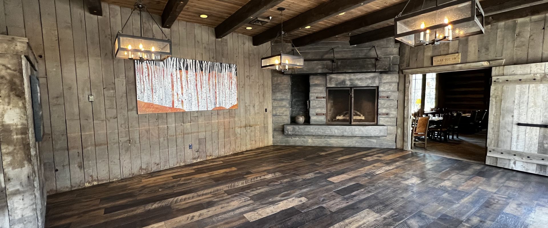 Rustic lodge interior with reclaimed wood walls and a stone fireplace