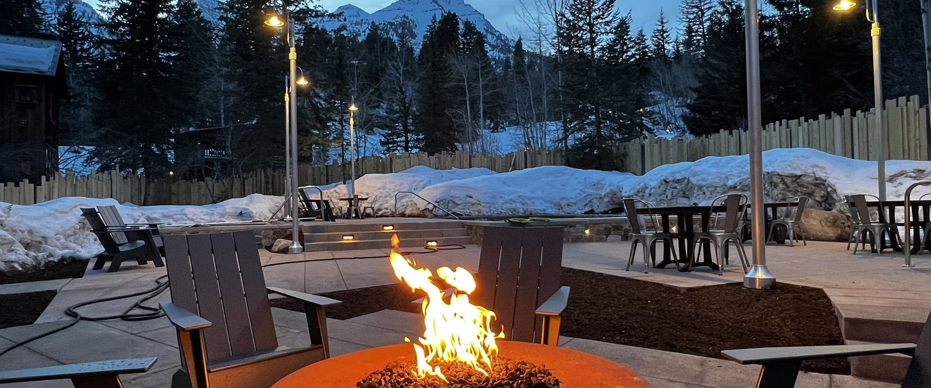 Fire pit and seating on a mountain patio at dusk
