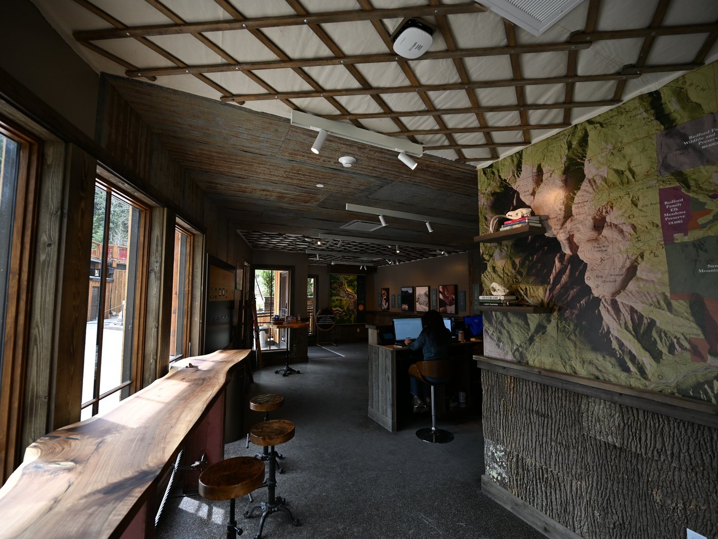 Activities center interior with live-edge wood counters and a mural wall