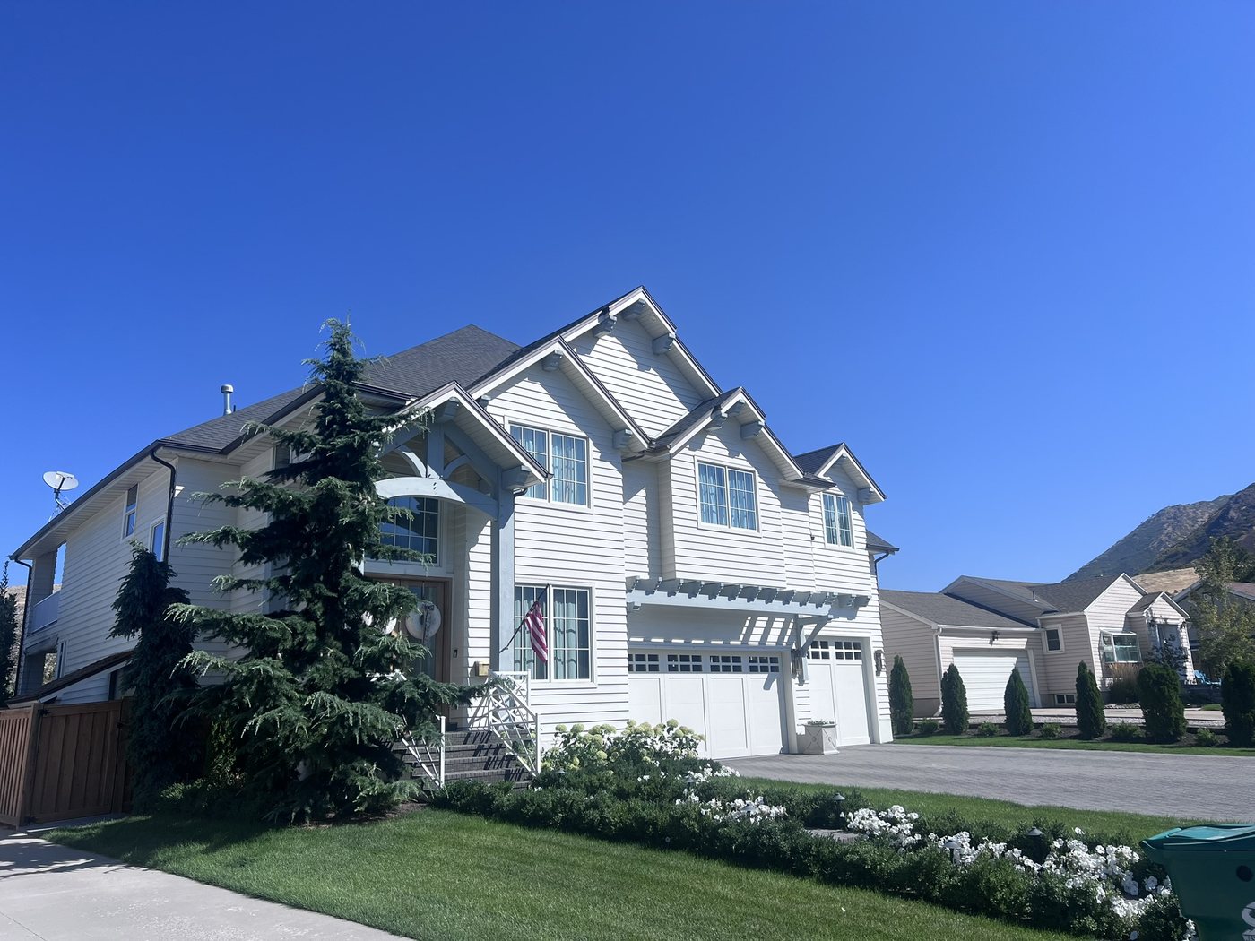 Whole-home exterior remodel with white lap siding and a pergola over the garage