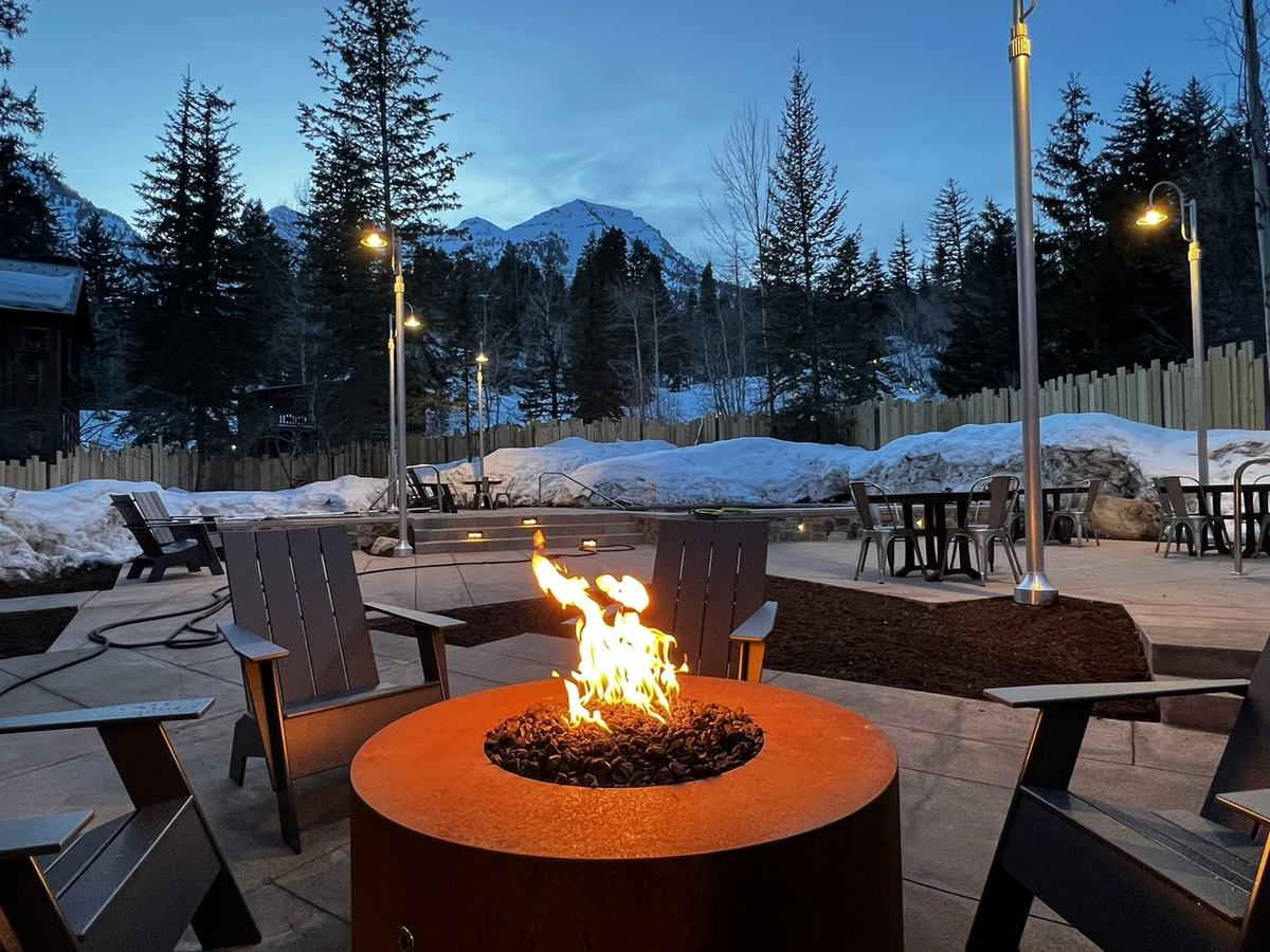 Fire pit and Adirondack seating on a mountain patio at dusk
