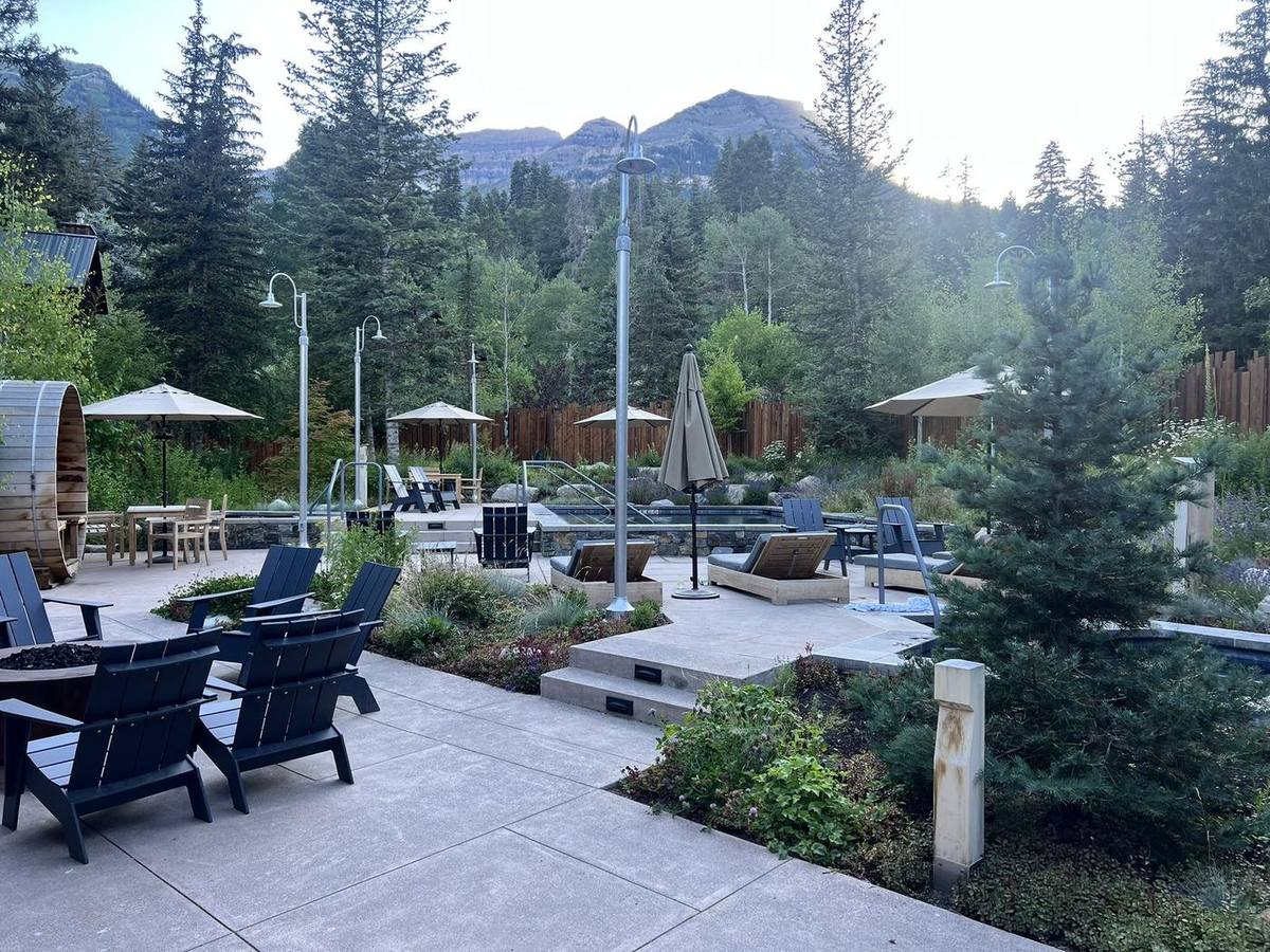 Adirondack chairs and planted beds on the patio at The Springs